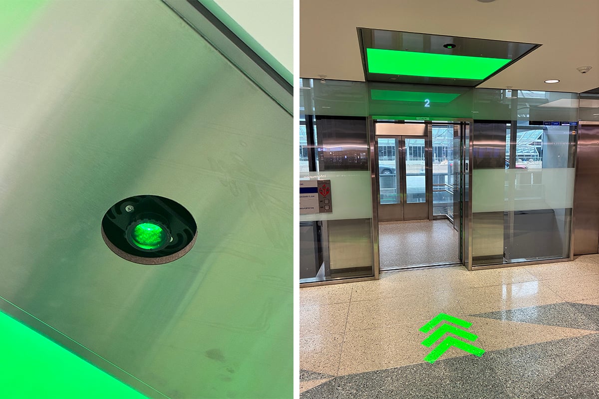 Airport lighting design featuring Rosco Image Spot HO projectors projecting green arrows outside elevators at Minneapolis-Saint Paul International Airport.