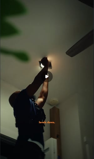 Filmmaker Joel Jovaine installs Rosco GripStrips on LED recessed can lights in an office ceiling to control lighting.