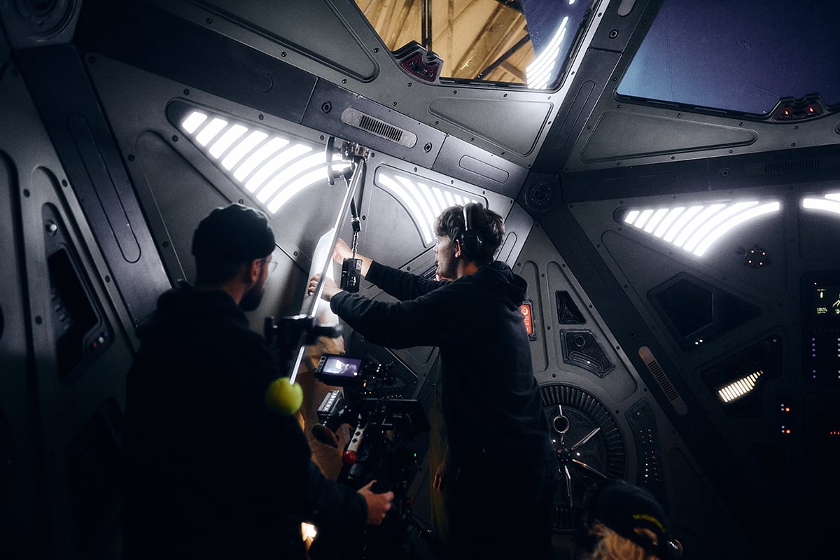 DoP Manuel Schamberger (left) and gaffer Lars Elliger (right) inside the  spacecraft set illuminated with DMG Lighting fixtures. 