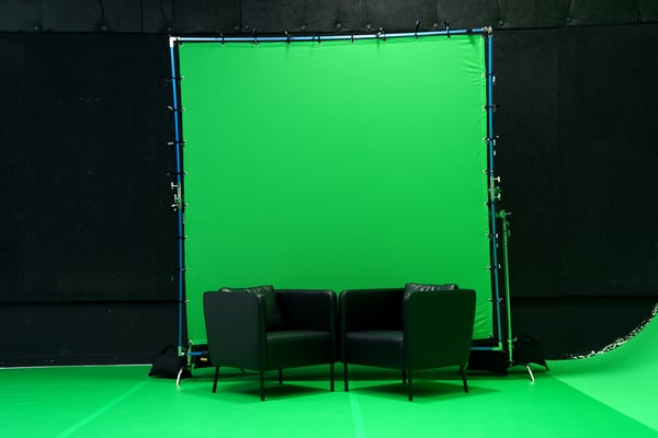 A Chroma Key Studio setup with a chroma key green butterfly behind two chairs that are on top of a chroma key green floor.