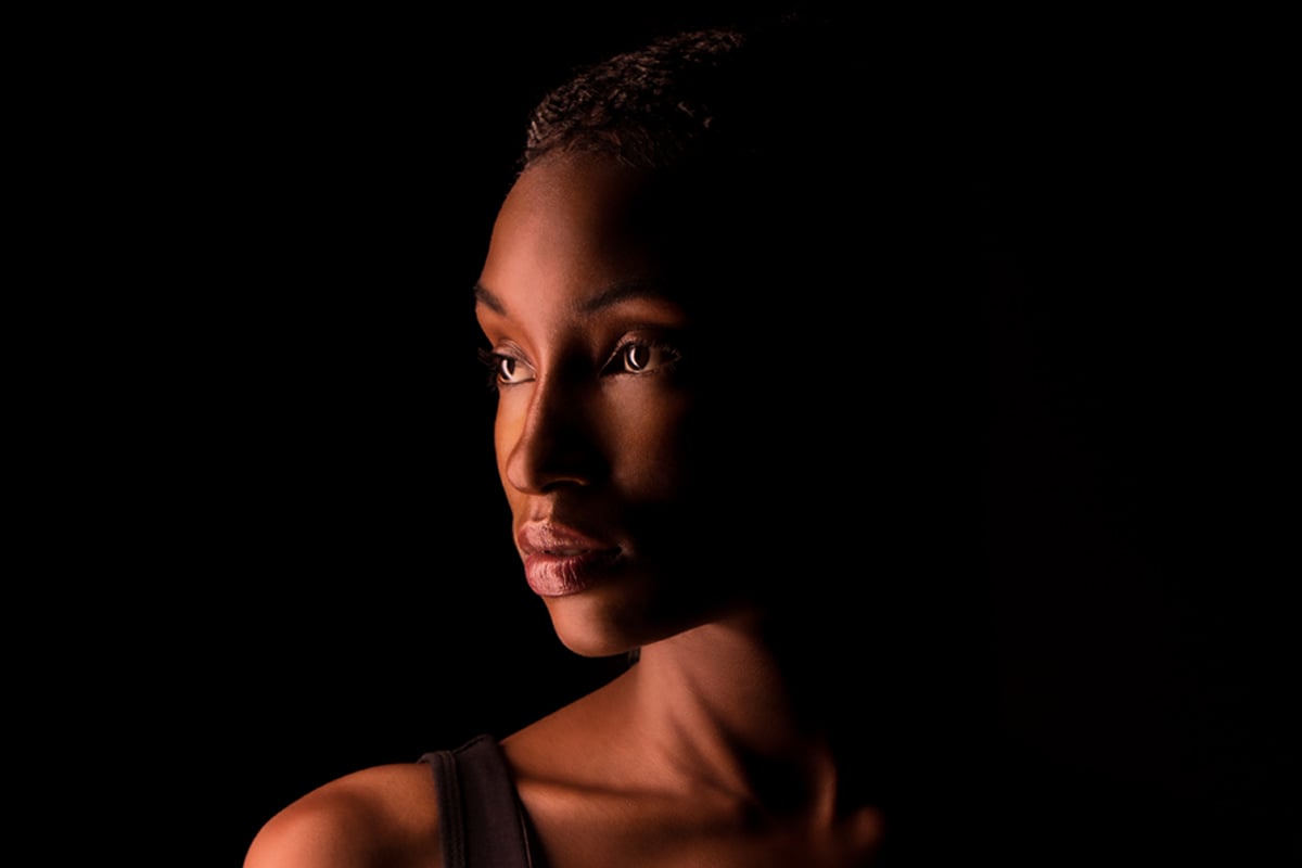 Face closeup of dark-skinned woman lit with DMG Lighting.