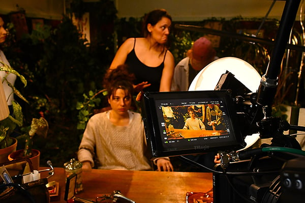 A film crew uses a Rosco DMG DASH light with a DOT Round Diffuser in their lighting setup to create eye light.