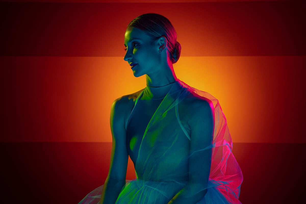 Portrait of a ballet dancer lit with contrasting colors.