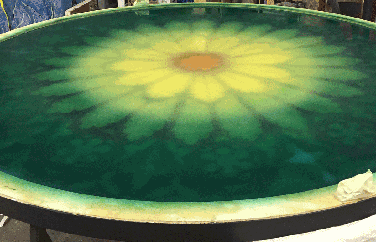 Green-yellow flower pattern painted on stained glass.