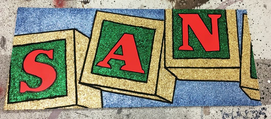 Sample board for a three-dimensional Santaland sign featuring Rosco CrystalGel and glitter, offering inspiration for Cinderella stage design.