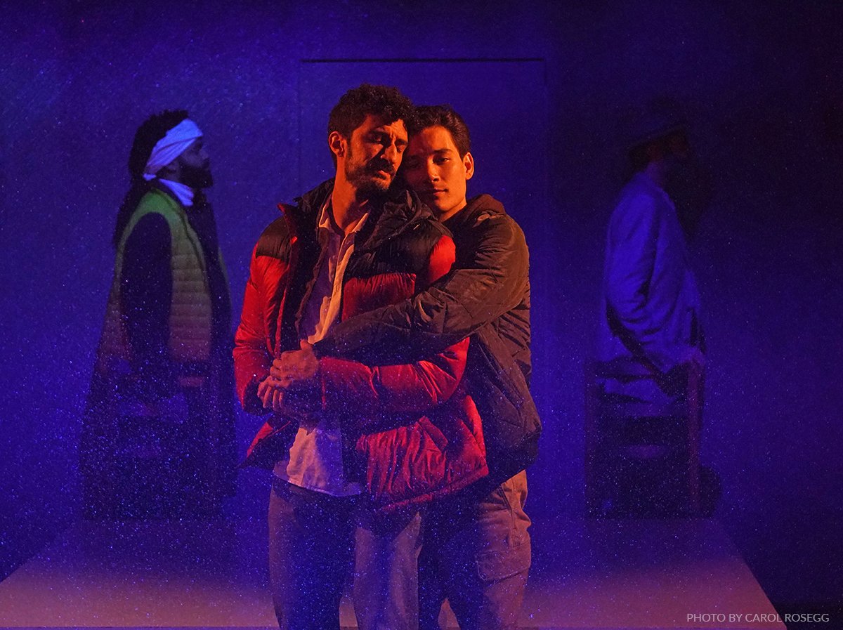 A couple on the stage immersed in blue and purple colors.