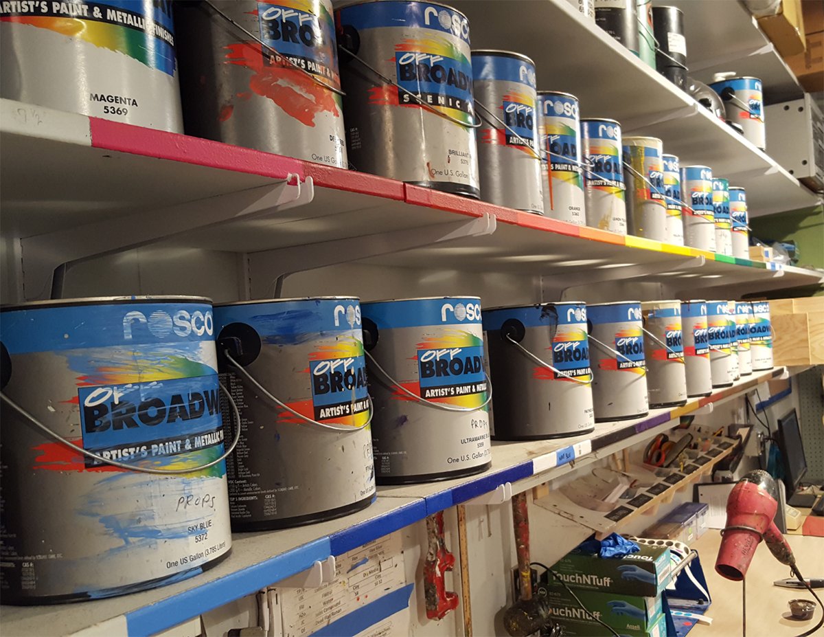 Rosco Off Broadway scenic paint stored on shelves in a scenic shop.