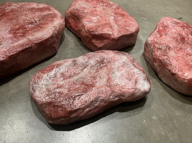 Four realistic-looking fake foam steaks that were created with Rosco Off Broadway scenic paint and Crystal Gel.