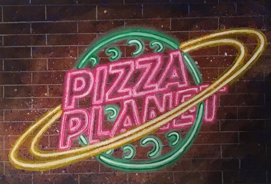 A "Pizza Planet" neon sign that was painted using Rosco Fluorescent paint for a scenic painting workshop at USITT 2019.