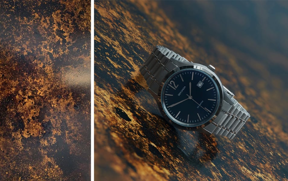 A watch sits on top a textured photoshoot backdrop that was created with Supersat Raw Umber paint.