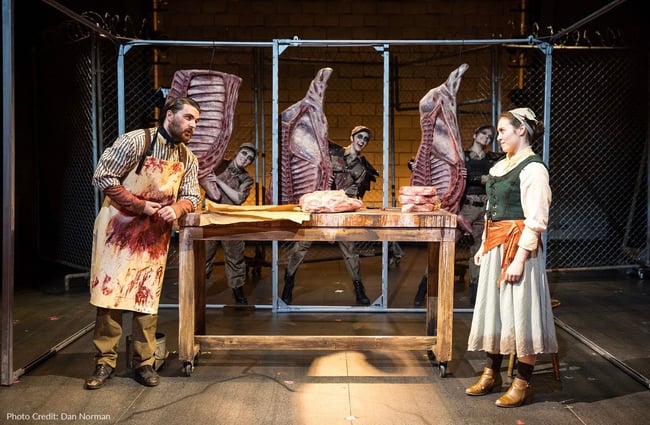 Actors on stage performing with fake sides of beef that were made of foam and Rosco Scenic Products.