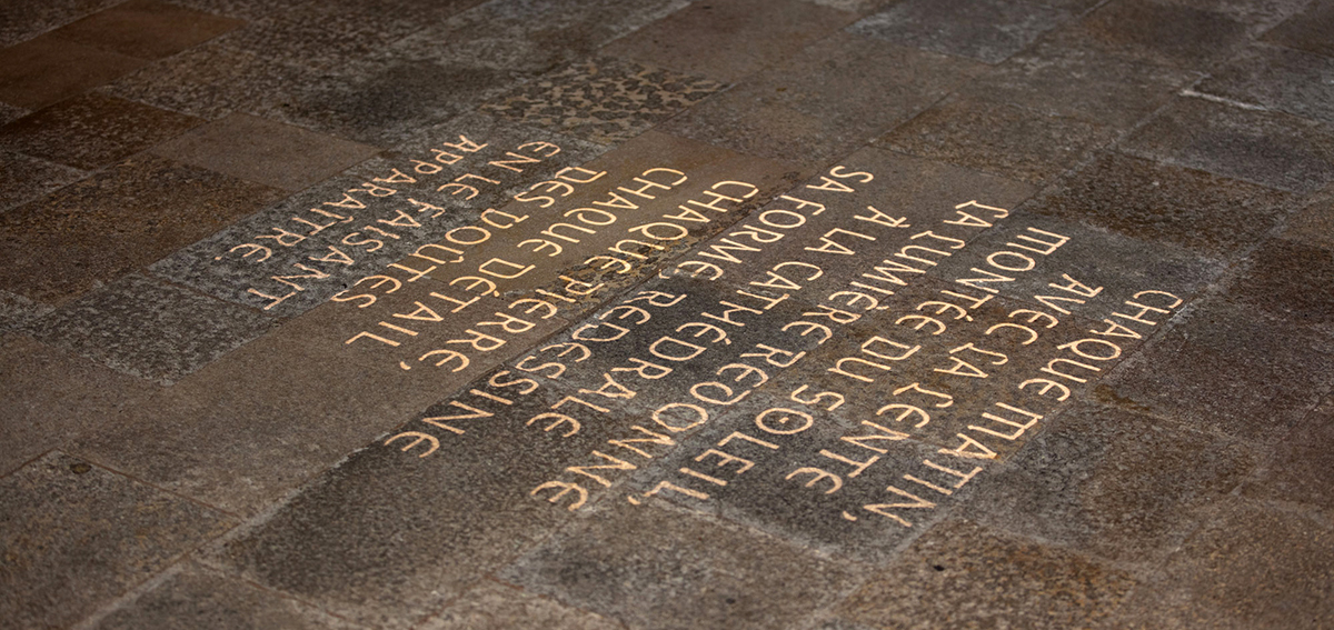 Gobo projection of the text on the floor inside the cathedral.